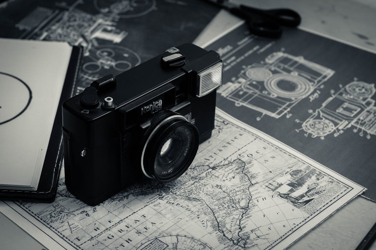 A vintage film camera placed on layered historical travel maps and blueprints